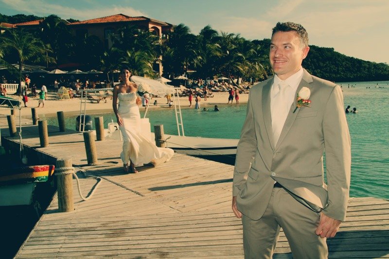 100 (9)b First look of bride and groom at dock in turquoise caribbean sea of Infinity Bay hotel- Roatan island wedding photographers